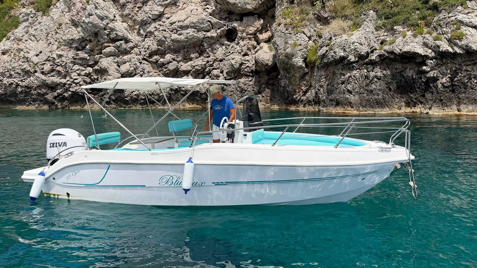 Blumax Open 23 a noleggio ormeggiata in una cala turchese vicino Taormina